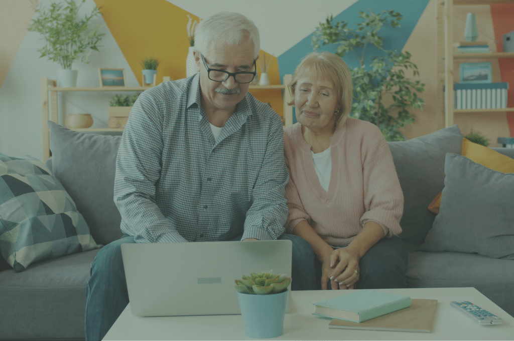 Older white couple looking at a laptop.